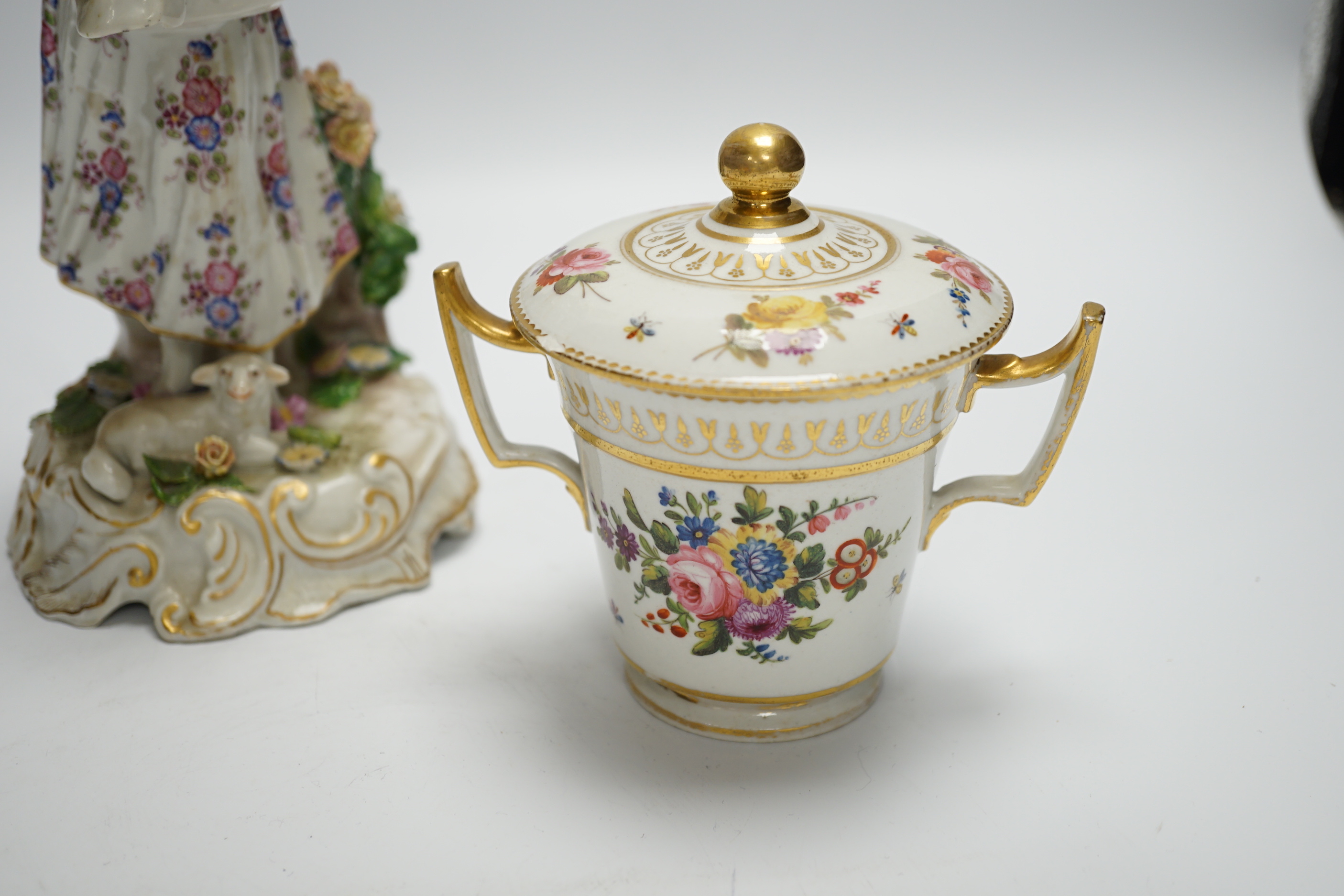 A late 19th century Continental porcelain figure of a lady, a Pinxton-type chocolate cup and cover, a Derby putti and a small Minton flower encrusted vase, figure 24.5cm (4)